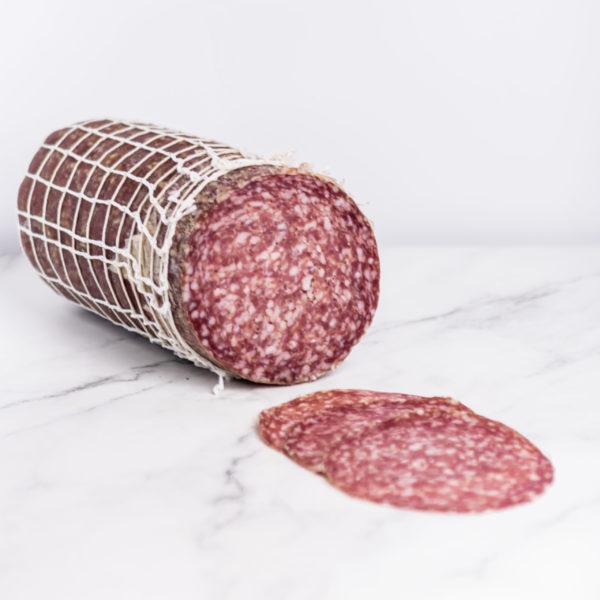 Dünn geschnittene Scheiben Salami Milano, traditionelle Mailänder Wurstwaren auf einem Marmorbrett. Bei My Little Italy