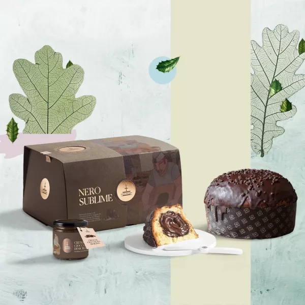Panettone Fiasconaro Nero Sublime au chocolat noir avec sa crème au café, présenté avec son coffret noir et blanc dans un décor botanique de fougères