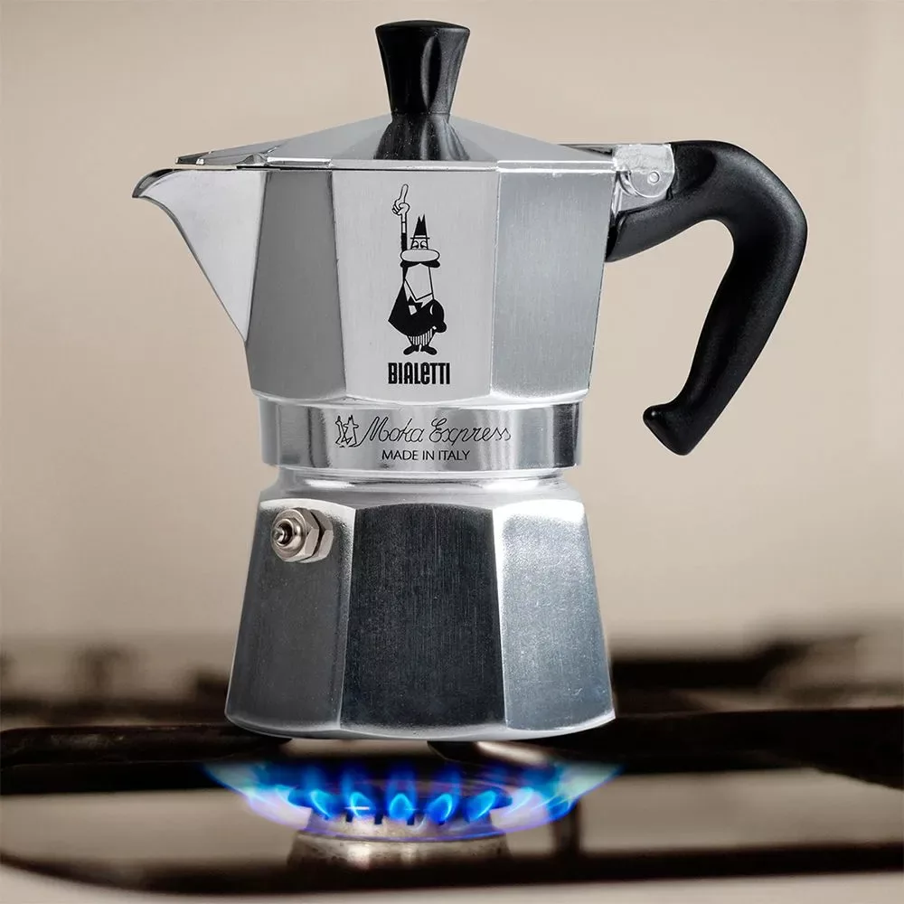Bialetti Moka Express en utilisation sur une flamme de gaz, capturant l'essence du rituel du café italien, offerte par My Little Italy