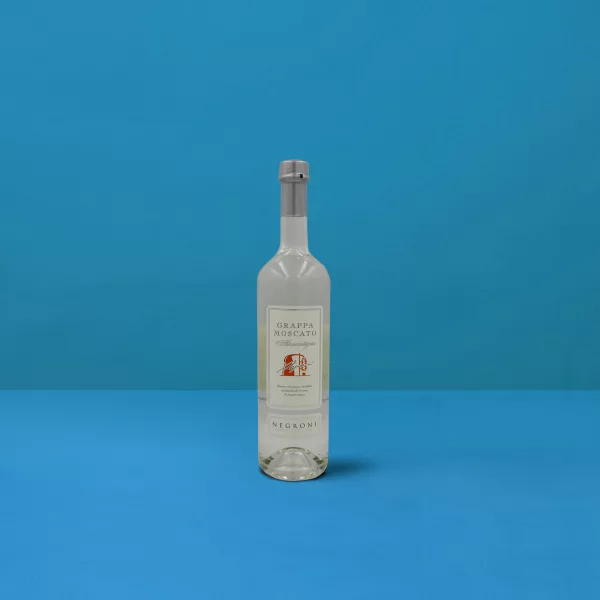 Bottiglia di Grappa Moscato Negroni (70cl) su sfondo blu, riflesso della distillazione artigianale e della qualità italiana.