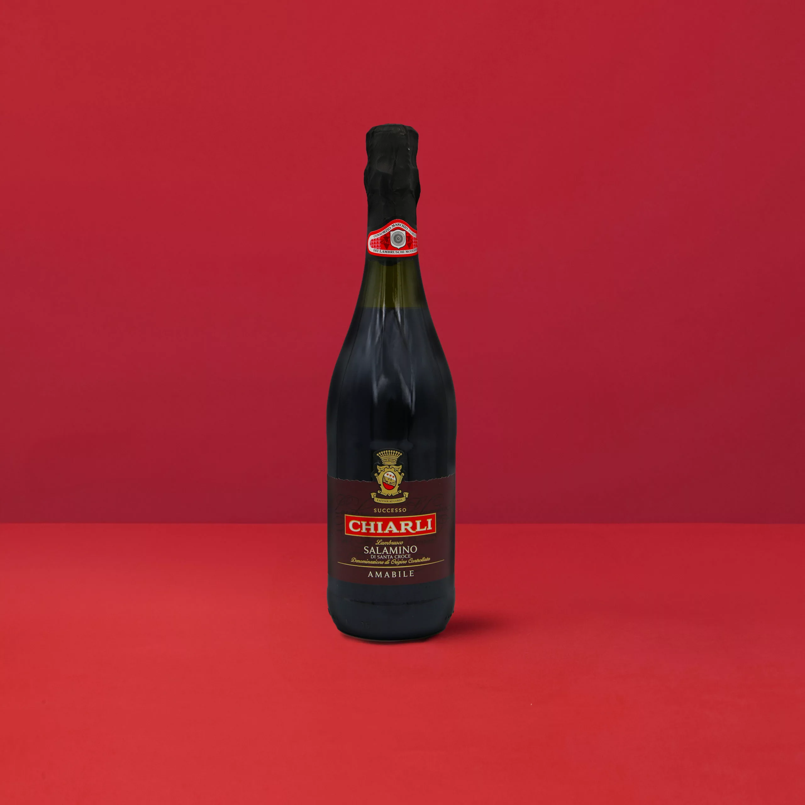 Flasche Lambrusco Classico Salamino - Chiarli DOC auf einem eleganten roten Hintergrund.