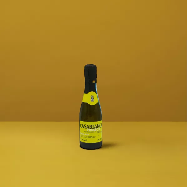 Une petite bouteille de Prosecchino Extra Dry Casabianca DOCG, avec sa couleur jaune clair et ses fines bulles, parfait pour un toast festif.