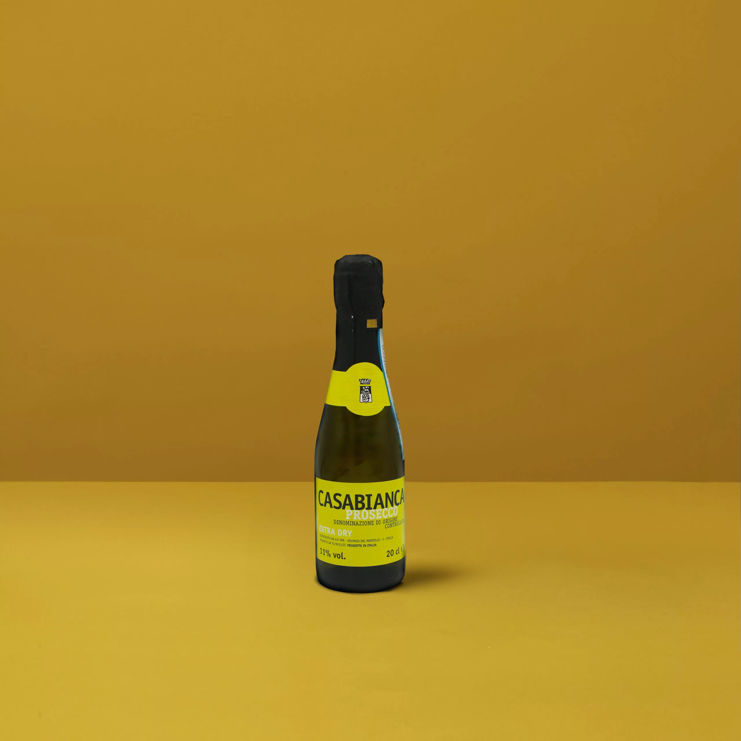 Une petite bouteille de Prosecchino Extra Dry Casabianca DOCG, avec sa couleur jaune clair et ses fines bulles, parfait pour un toast festif.