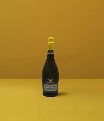 Una bottiglia di Prosecco Extra Dry Filipetti su sfondo giallo, simbolo di finezza e celebrazione italiana.
