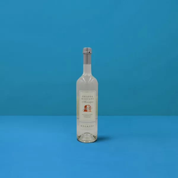Bottiglia di Grappa Moscato Negroni (70cl) su sfondo blu, riflesso della distillazione artigianale e della qualità italiana.