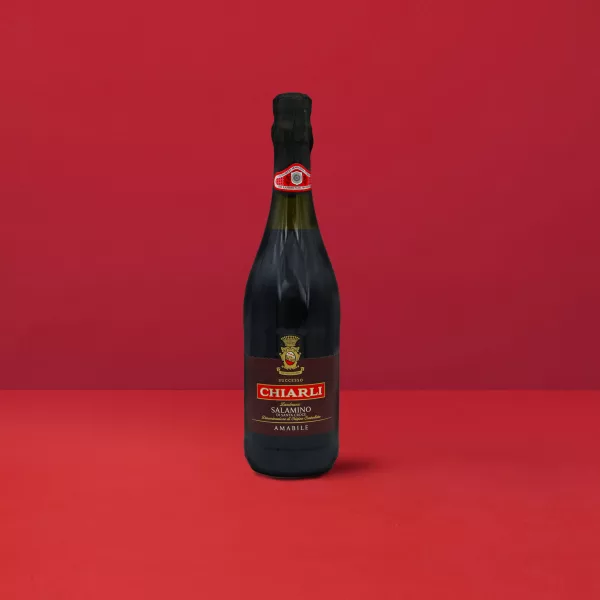 Bottiglia di Lambrusco Classico Salamino - Chiarli DOC su un elegante sfondo rosso.