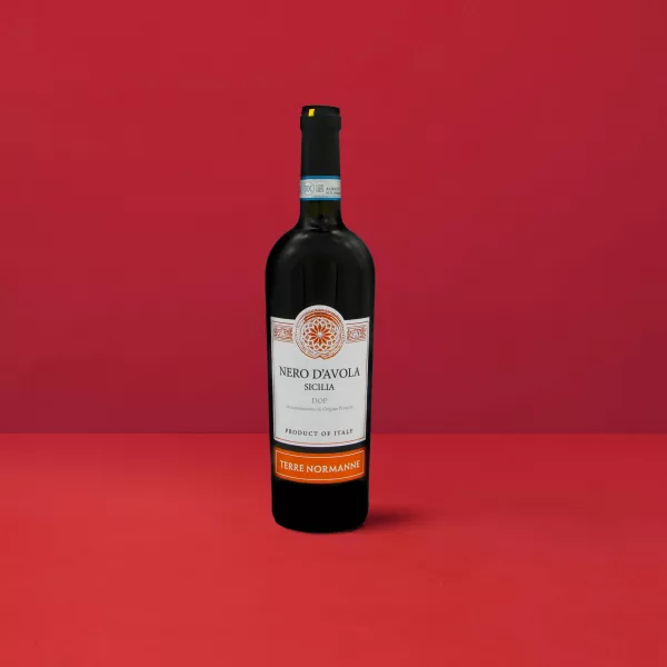 Flasche Nero d&#039;Avola - Terre Normanne DOP, die das intensive Rot und die granatroten Reflexe widerspiegelt, die für den sizilianischen Wein charakteristisch sind.
