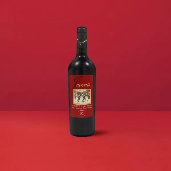 Bottiglia di Primitivo di Manduria Juvenis DOP che esprime il colore rosso rubino intenso e la vitalità del vino di Manduria.