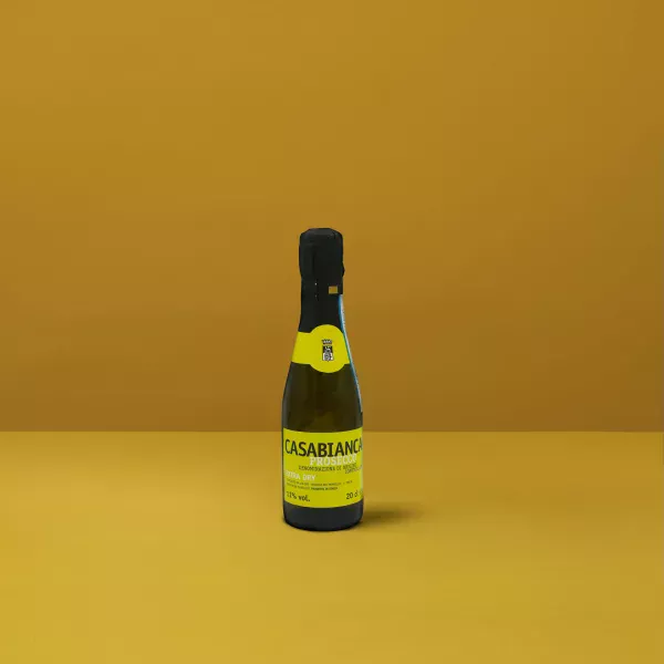 Eine kleine Flasche Prosecchino Extra Dry Casabianca DOCG mit seiner hellgelben Farbe und den feinen Bläschen, perfekt für einen festlichen Toast.