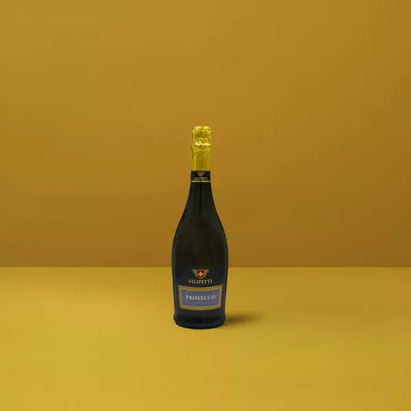 Filipetti Extra Dry Prosecco-Flasche auf gelbem Hintergrund, ein Symbol für Finesse und italienische Feierlichkeit.