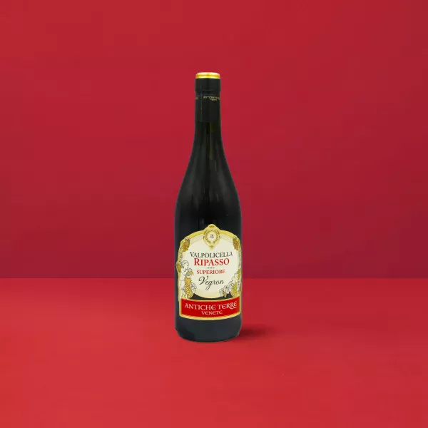 Bottiglia di Valpolicella Ripasso Superiore Antiche Terre DOC su sfondo rosso