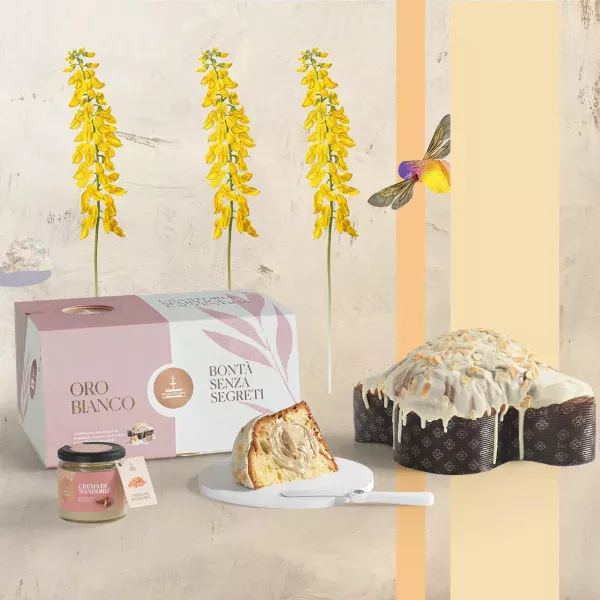 Colombe de Pâques Oro Bianco de Fiasconaro avec sa couverture de chocolat blanc et amandes, présentée avec son pot de crème et son spalmino